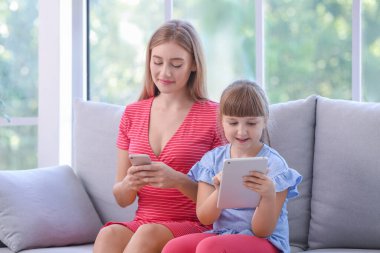 Evde modern aletleri olan bir anne ve kız.