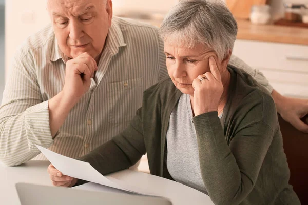 Stressed senior couple in debt at home