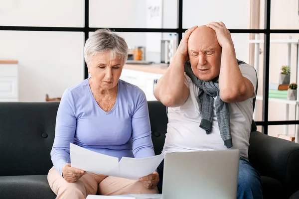 Stressed senior couple in debt at home