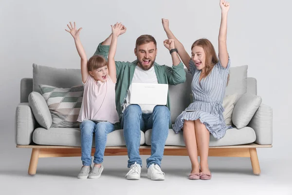 Família Feliz Com Laptop Moderno Sofá Contra Fundo Leve — Fotografia de Stock