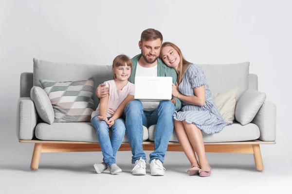 Família Feliz Com Laptop Moderno Sofá Contra Fundo Leve — Fotografia de Stock