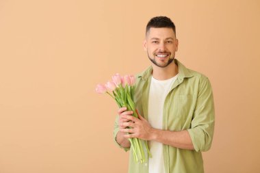 Renkli arka planda bir buket güzel çiçekli yakışıklı adam.