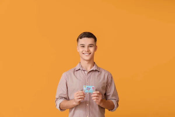 Teenager Junge Mit Geschenkkarte Auf Farbigem Hintergrund — Stockfoto