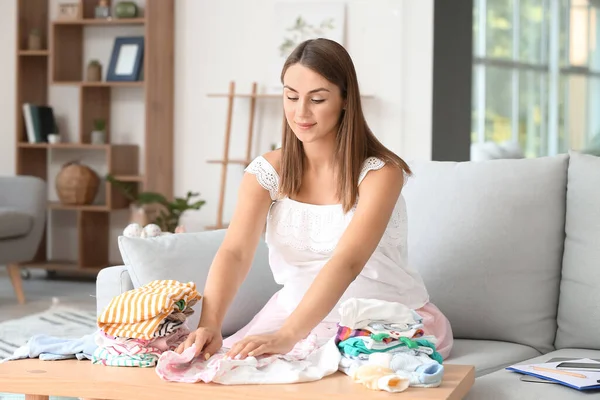 Schöne Schwangere Frau Mit Babykleidung Hause — Stockfoto