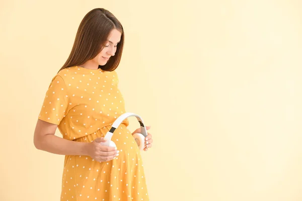 배경에 헤드폰을 아름다운 임산부 — 스톡 사진