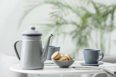 Çaydanlık ve fincan, masada çay.