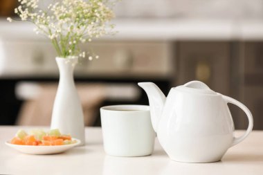 Çaydanlık ve fincan, odadaki ışık masasında çay.