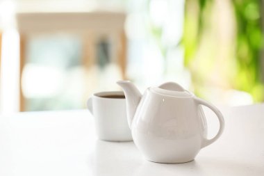 Çaydanlık ve fincan, odadaki ışık masasında çay.