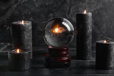 Kristal falcı küresi ve koyu arkaplanda mumlar