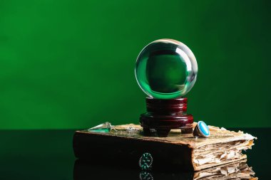 Kristal falcı küresi ve renk arkaplanı üzerine eski kitap