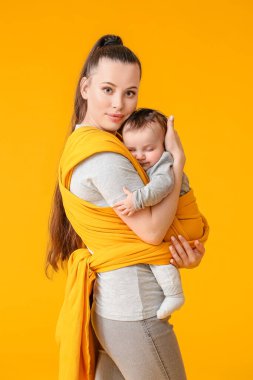 Arka planda küçük bir bebeği olan genç bir anne.