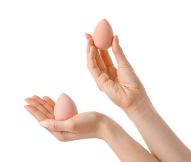 Beyaz arkaplanda makyaj süngeri olan eller