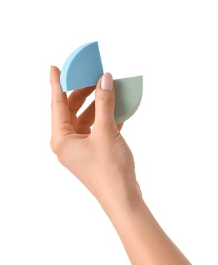 Beyaz arkaplanda makyaj süngeri olan el