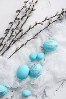 Beautiful Easter eggs and pussy willow on light background