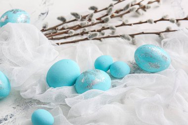 Beautiful Easter eggs and pussy willow on light background