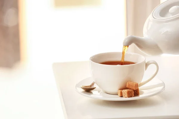 Tee Aus Teekanne Tasse Auf Hellem Tisch Gießen — Stockfoto