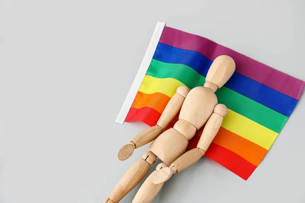 浅色背景的带彩虹旗的木制人体模特 — 图库照片