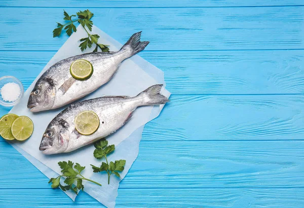 Maydanozlu çiğ dorado balığı ve ahşap renkte limon.