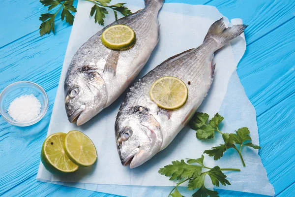 Maydanozlu çiğ dorado balığı ve ahşap renkte limon.