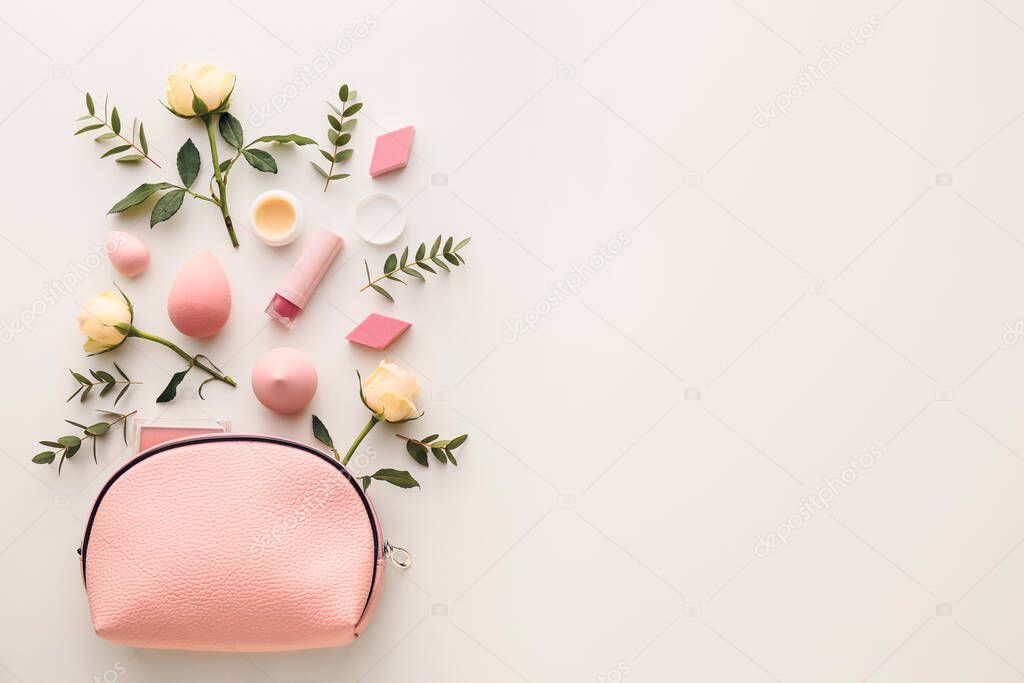 Cosmetic bag and flowers on white background