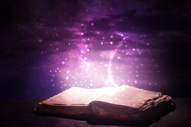Karanlık arkaplan üzerine sihirli kitap aç