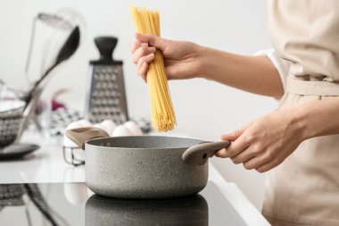 Kadın mutfakta lezzetli makarna pişiriyor.