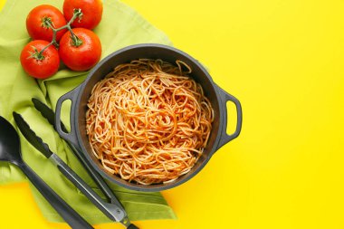 Makarnalı tencere, domates ve mutfak gereçleri.