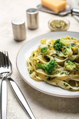 Hafif arka planda lezzetli makarna ve brokoli tabağı, yakın plan.