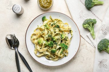 Hafif arka planda lezzetli makarna ve brokoli tabağı.