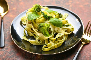 Arkaplanda brokoli olan lezzetli bir makarna, yakın plan.