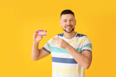 Arkaplanda hediye kartı olan yakışıklı bir adam.