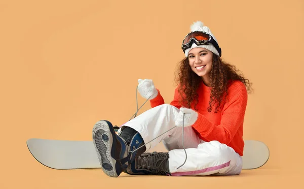 Femme Snowboarder Mettre Des Chaussures Sur Fond Couleur — Photo