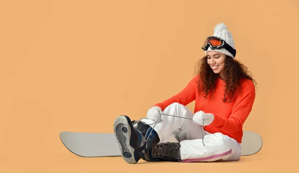 Female Snowboarder Putting Shoes Color Background — Stock Photo, Image