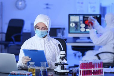 Bilimadamı laboratuvarda örnek üzerinde çalışıyor.