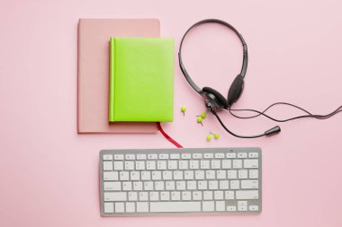 Renk arkaplanında dizüstü bilgisayarlı klavyeli kulaklık