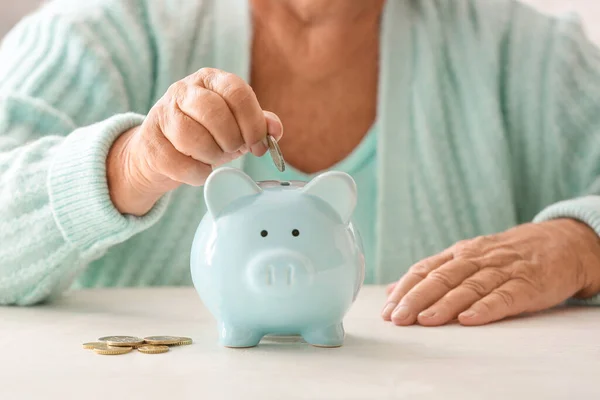 Mulher Sênior Colocando Moeda Banco Porquinho Mesa Conceito Pensão — Fotografia de Stock