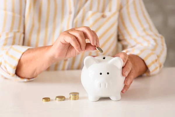 Kvinna Som Lägger Mynt Spargrisen Vid Bordet Begreppet Pension — Stockfoto