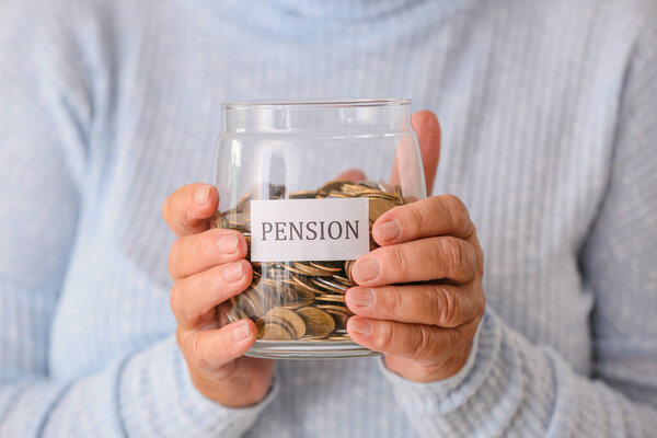 Senior woman with savings in jar, closeup. Concept of pension