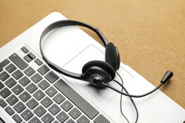 Renkli arkaplanda dizüstü bilgisayarı olan kulaklık