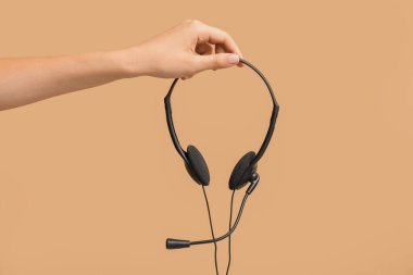 Renk arkaplanında kulaklığı olan bir kadın el
