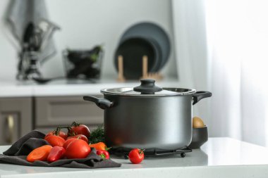 Mutfaktaki masada tencere ve sebzeler.