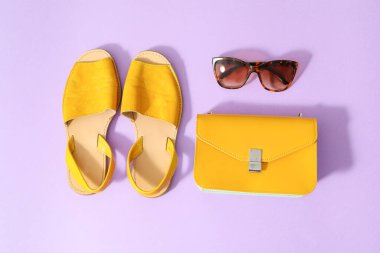 Renkli arka planda kadın aksesuarları ve güneş gözlükleri.