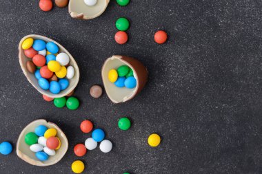 Koyu arkaplanda lezzetli çikolata yumurtaları ve şekerler.