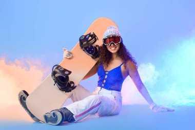 Renkli arka planda kadın snowboardcu