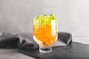 Grunge arka planında lezzetli jöle küpleri olan bir bardak.