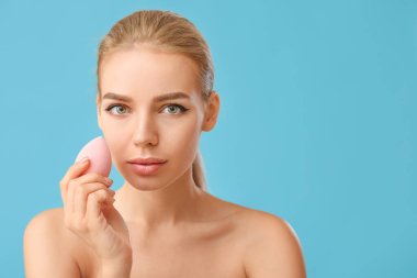 Renkli makyaj süngeri olan güzel bir genç kadın.