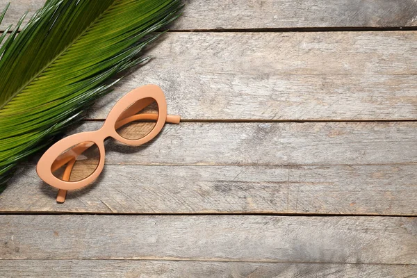 Elegantes Gafas Sol Hoja Tropical Sobre Fondo Madera — Foto de Stock