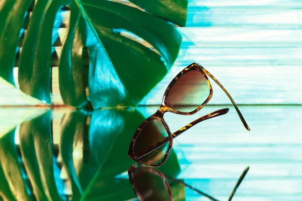 Stylish Female Sunglasses Tropical Leaf Table — Stock Photo, Image