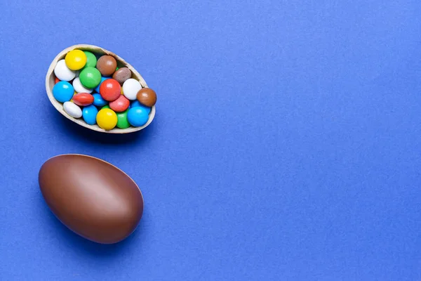 おいしいチョコレートの卵とキャンディーの色の背景 — ストック写真
