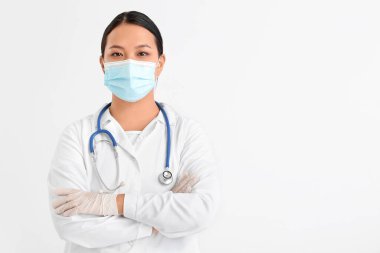 Hafif arka planda tıbbi maskeli kadın Asyalı doktorun portresi